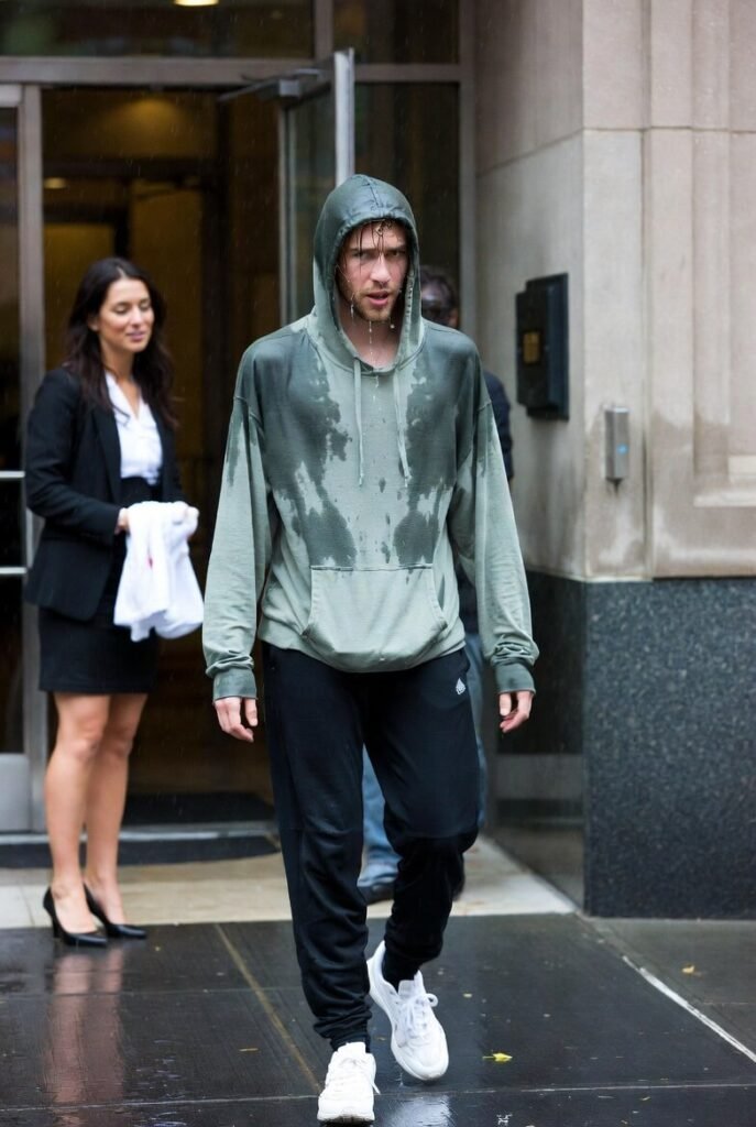 Soaked man in hoodie entering job interview in rain
